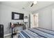 Bedroom featuring ceiling fan, light gray walls, and desk beneath mounted TV at 4007 S Renellie Dr, Tampa, FL 33611