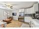 Open-concept kitchen with white cabinets, stainless steel appliances, and hardwood flooring at 4007 S Renellie Dr, Tampa, FL 33611