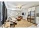 Open-concept living area with hardwood floors, a flat-screen TV, and a stainless steel refrigerator at 4007 S Renellie Dr, Tampa, FL 33611