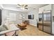 Cozy living room with hardwood floors, a comfortable couch, and a modern stainless steel refrigerator at 4007 S Renellie Dr, Tampa, FL 33611