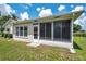 Exterior image showcasing a light stucco home with a screened-in patio and manicured backyard space at 4646 Lacrosse Ct, New Port Richey, FL 34655