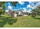 A spacious backyard with a light stucco home, featuring a screened-in patio and lush lawn at 4646 Lacrosse Ct, New Port Richey, FL 34655