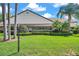 Charming home featuring manicured landscaping, decorative shrubbery, and tall palms, enhancing its curb appeal at 4646 Lacrosse Ct, New Port Richey, FL 34655