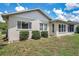 Rear exterior view showcasing the home's light stucco, trimmed hedges, and well-maintained lawn at 4646 Lacrosse Ct, New Port Richey, FL 34655
