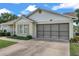 A bright, single-story home with a large screened garage door and a well-maintained lawn at 4646 Lacrosse Ct, New Port Richey, FL 34655