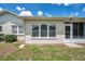 Home exterior showing clean stucco, symmetrical windows, and a door leading to screened patio at 4646 Lacrosse Ct, New Port Richey, FL 34655