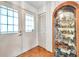 Bright foyer featuring a wood floor, closet, front door with sidelight, and a display cabinet at 4646 Lacrosse Ct, New Port Richey, FL 34655