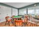 Well-lit game room with game table, chairs, storage shelves and board games for residents' enjoyment at 4646 Lacrosse Ct, New Port Richey, FL 34655
