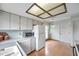 Well-lit kitchen with laminate wood flooring, white appliances, and a decorative mural on the wall at 4646 Lacrosse Ct, New Port Richey, FL 34655