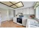 Bright kitchen featuring laminate wood floors, white countertops, white cabinets and black oven at 4646 Lacrosse Ct, New Port Richey, FL 34655