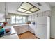 U-shaped kitchen featuring a window above sink, laminate wood floors, and white refrigerator at 4646 Lacrosse Ct, New Port Richey, FL 34655