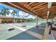 Community shuffleboard courts with covered seating areas and mature palm trees at 4646 Lacrosse Ct, New Port Richey, FL 34655