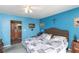 Comfortable blue bedroom featuring a decorative headboard and side view of the en-suite bath at 4939 Floramar Ter # 203, New Port Richey, FL 34652