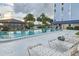 Outdoor community pool featuring lounge chairs, palm trees, and a pavilion, perfect for relaxation and socializing at 4939 Floramar Ter # 203, New Port Richey, FL 34652