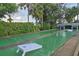 Community shuffleboard court surrounded by lush greenery, offering a fun outdoor recreational activity at 4939 Floramar Ter # 203, New Port Richey, FL 34652