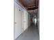Long storage hallway with white doors, overhead lighting, and concrete floors at 4939 Floramar Ter # 812, New Port Richey, FL 34652