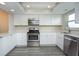 Modern kitchen with stainless steel appliances and white cabinets offering a clean, contemporary aesthetic at 4939 Floramar Ter # 812, New Port Richey, FL 34652