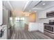 Open-concept kitchen showcasing bright white cabinets, stainless appliances, and hardwood-style floors at 4939 Floramar Ter # 812, New Port Richey, FL 34652