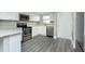 Well-lit kitchen featuring stainless steel appliances, white cabinets, and gray wood-look floors at 4939 Floramar Ter # 812, New Port Richey, FL 34652