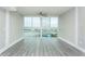 Inviting living room featuring large windows with scenic water views, paired with a modern ceiling fan at 4939 Floramar Ter # 812, New Port Richey, FL 34652