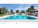 Large community swimming pool with ample seating, a gazebo, and bright blue water on a sunny day at 4939 Floramar Ter # 812, New Port Richey, FL 34652