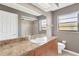 Full bathroom features a vanity with sink, large mirror and tiled shower at 5021 Bridgeport Dr, Safety Harbor, FL 34695