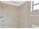 Tiled shower with neutral earth tones, adjustable showerhead, and built-in shelving at 5021 Bridgeport Dr, Safety Harbor, FL 34695
