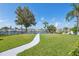 Scenic backyard with lush green grass, landscaping, and waterfront views overlooking a canal at 5348 Lawrence Ln, New Port Richey, FL 34652