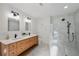 Bright bathroom featuring double vanity with modern fixtures, a marble shower, and decorative wall art at 5348 Lawrence Ln, New Port Richey, FL 34652