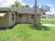 Exterior shot of the back of a single-story home with simple windows and green grass at 6030 17Th St, Zephyrhills, FL 33542