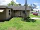Backyard featuring healthy green grass and the rear of a modest residential home under a sunny sky at 6030 17Th St, Zephyrhills, FL 33542