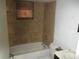 Bathroom featuring a tiled shower over the tub, a tiled accent wall and window at 6030 17Th St, Zephyrhills, FL 33542