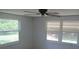 Bright bedroom with ceiling fan and two large windows providing an outdoor view at 6030 17Th St, Zephyrhills, FL 33542