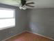 Bedroom with hardwood floors, a ceiling fan, and a window for natural light at 6030 17Th St, Zephyrhills, FL 33542