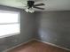 Simple bedroom with ceiling fan, wood floors, and plenty of natural light from a window at 6030 17Th St, Zephyrhills, FL 33542