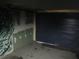 Dark garage featuring rough unfinished walls and roll-up door at 6030 17Th St, Zephyrhills, FL 33542