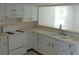 White cabinets and appliances in this kitchen are brightened by a window over the sink at 6030 17Th St, Zephyrhills, FL 33542