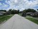 Quiet residential street lined with single-Gathering homes and mature trees under a partly cloudy sky at 6030 17Th St, Zephyrhills, FL 33542