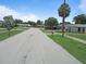 Residential street featuring single-Gathering homes with green lawns and mature palm trees at 6030 17Th St, Zephyrhills, FL 33542