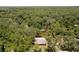 Aerial view showcasing the property surrounded by lush green trees and a winding river at 6410 Amelia Ln, Dade City, FL 33523