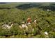 Aerial view of home surrounded by lush greenery and winding river at 6410 Amelia Ln, Dade City, FL 33523