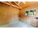 Bedroom featuring wood-paneled walls, a ceiling fan, and a window at 6410 Amelia Ln, Dade City, FL 33523