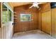 Bedroom featuring wood-paneled walls, a ceiling fan, a closet and large windows at 6410 Amelia Ln, Dade City, FL 33523