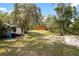 Exterior view of an orange house surrounded by trees and an expansive grassy yard at 6410 Amelia Ln, Dade City, FL 33523