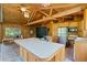 Well-lit kitchen featuring wood paneling, stainless appliances, and a large island with cooktop offering charm and functionality at 6410 Amelia Ln, Dade City, FL 33523