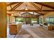Spacious living area featuring wood paneled walls, large windows with beautiful backyard views, and a vaulted ceiling at 6410 Amelia Ln, Dade City, FL 33523