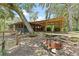 Outdoor living space featuring a patio and fire pit, surrounded by trees at 6410 Amelia Ln, Dade City, FL 33523