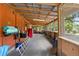 Screened porch with wood beams, wood walls, and view of the surrounding greenery at 6410 Amelia Ln, Dade City, FL 33523