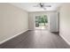Bedroom with sleek gray floors, light walls, and door leading to the outside at 6509 Pine Meadows Dr, Spring Hill, FL 34606