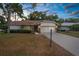 Charming single-story home featuring stone accents, a two-car garage, and mature landscaping at dusk at 6509 Pine Meadows Dr, Spring Hill, FL 34606